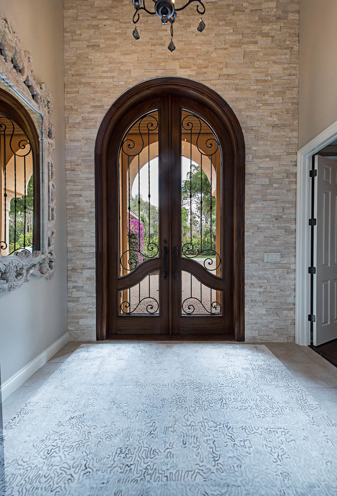 Ispirazione per una grande porta d'ingresso tradizionale con pareti beige, pavimento in gres porcellanato, una porta a due ante, una porta in legno bruno e pavimento beige