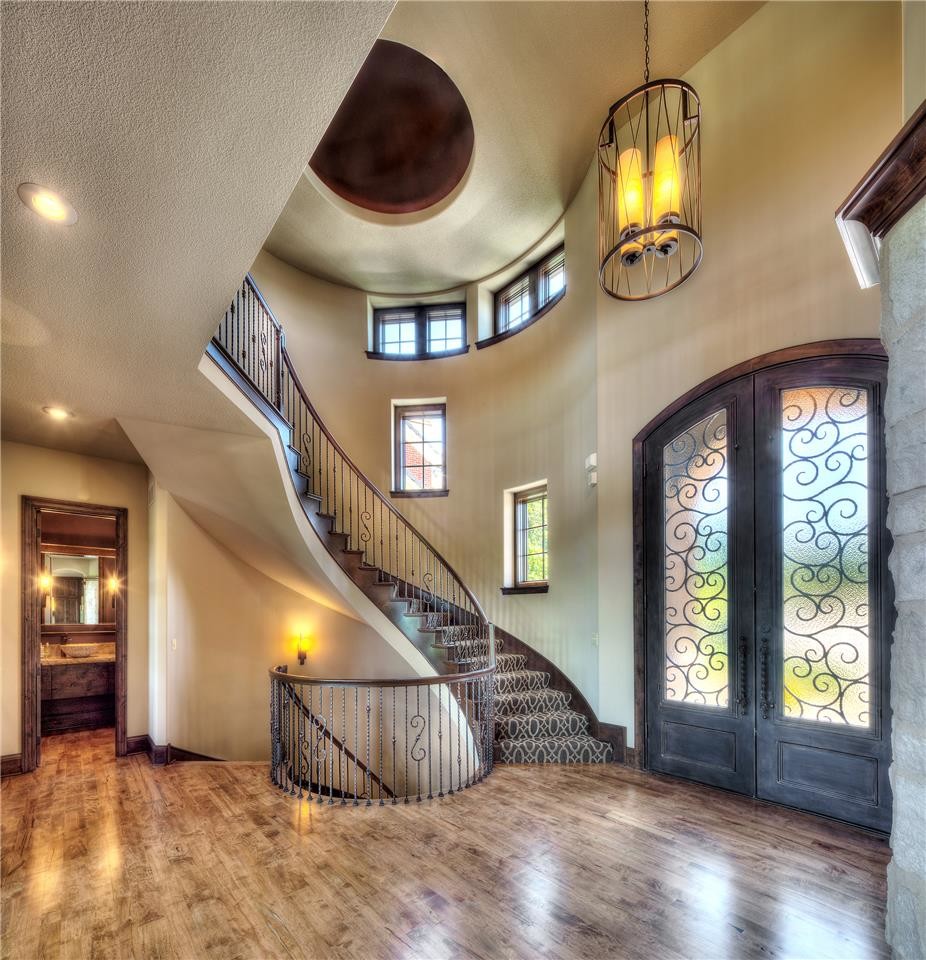 Example of a large tuscan light wood floor entryway design in Other with beige walls and a gray front door