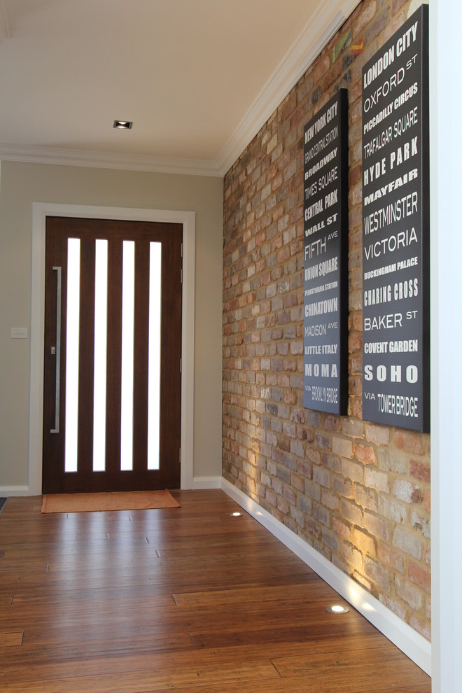 Foto de puerta principal actual de tamaño medio con paredes grises, suelo de madera en tonos medios, puerta simple y puerta de madera en tonos medios