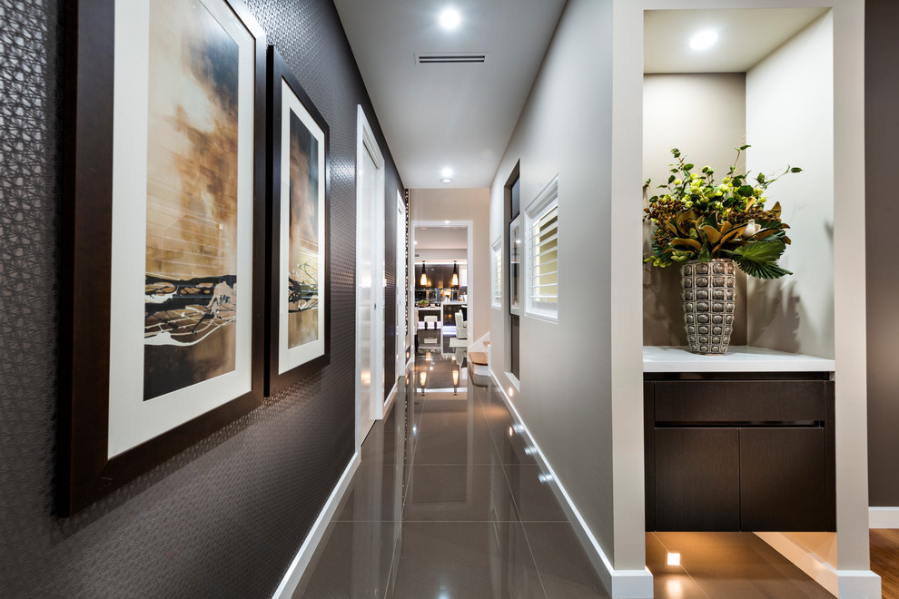 Foto di un corridoio minimal di medie dimensioni con pavimento in gres porcellanato, pareti con effetto metallico, una porta a due ante, una porta in legno scuro e pavimento grigio