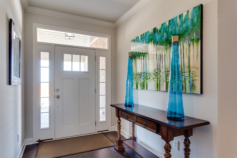 Aménagement d'une entrée classique de taille moyenne avec un couloir, un mur beige, parquet foncé, une porte simple et une porte blanche.