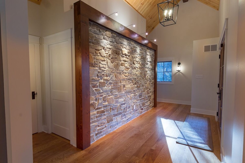 Mittelgroßes Uriges Foyer mit grauer Wandfarbe, hellem Holzboden, Doppeltür und dunkler Holzhaustür in Burlington
