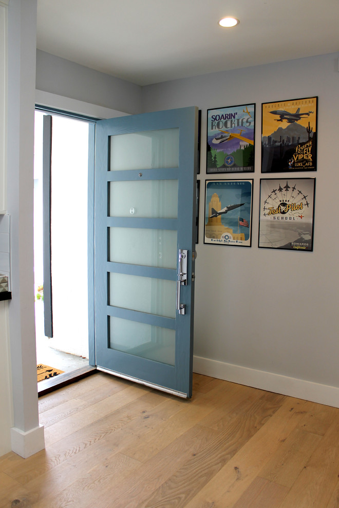 Ispirazione per una piccola porta d'ingresso minimalista con pareti blu, parquet chiaro, una porta singola, una porta blu e pavimento beige