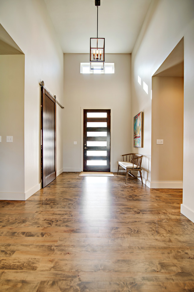 Entryway - large modern medium tone wood floor entryway idea in Other with gray walls and a dark wood front door
