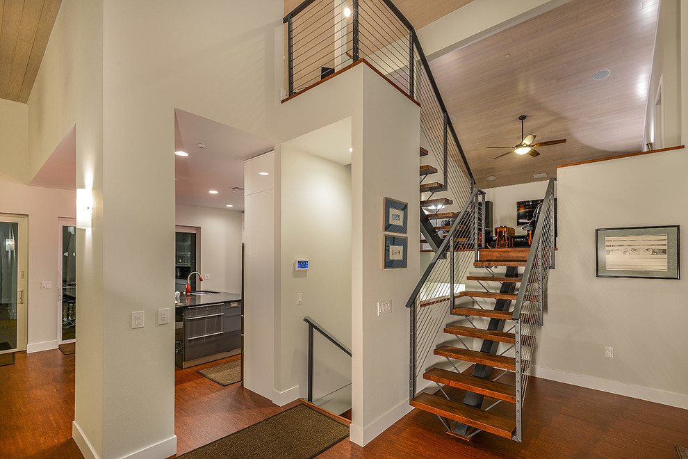 This is an example of a contemporary entrance in Tampa with white walls and bamboo flooring.