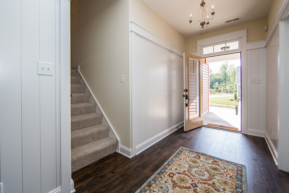Esempio di un ingresso di medie dimensioni con pareti grigie, pavimento in legno massello medio, una porta singola, una porta arancione e pavimento marrone