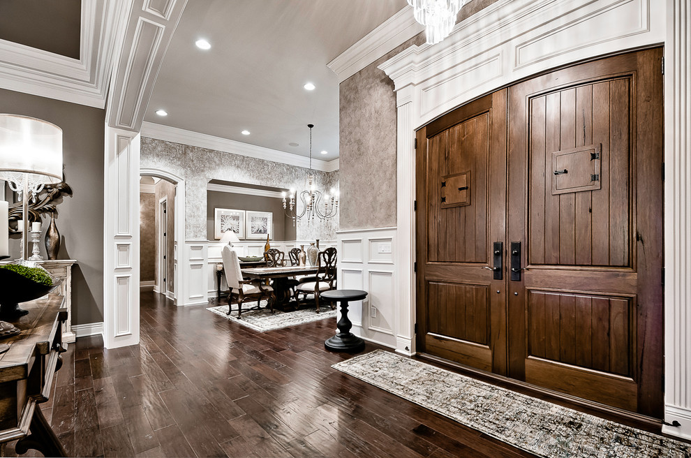 This is an example of a medium sized traditional vestibule in Other with beige walls, dark hardwood flooring, a double front door, a dark wood front door and brown floors.