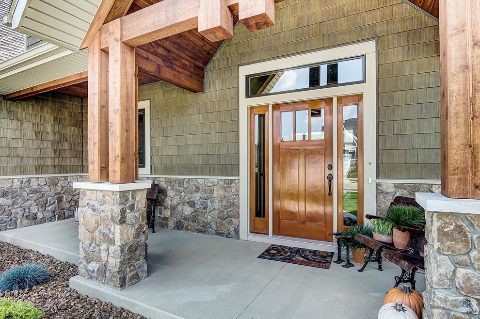 Große Rustikale Haustür mit grüner Wandfarbe, Betonboden, Einzeltür, grauem Boden und hellbrauner Holzhaustür in Sonstige
