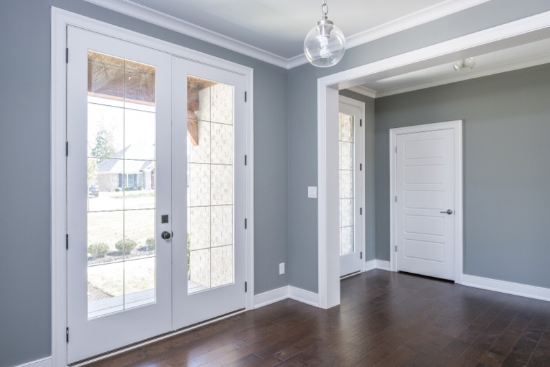 Пример оригинального дизайна: входная дверь среднего размера в стиле неоклассика (современная классика) с синими стенами, полом из винила, одностворчатой входной дверью и белой входной дверью