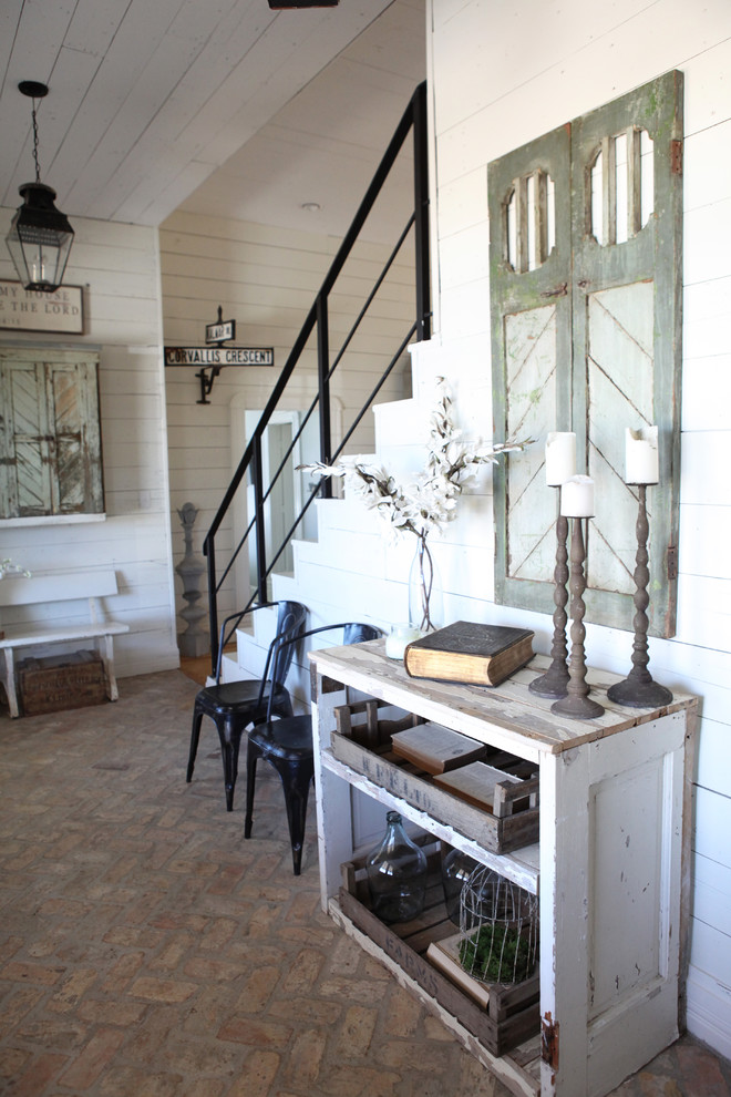 Inspiration for a mid-sized shabby-chic style brick floor entry hall remodel in Austin with white walls and a medium wood front door