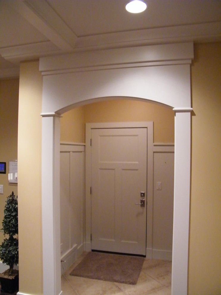 На фото: прихожая в стиле кантри с желтыми стенами, одностворчатой входной дверью и входной дверью из дерева среднего тона с