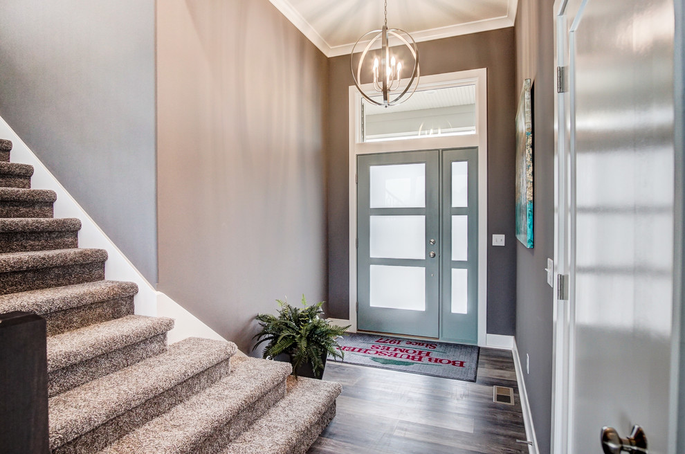 Imagen de puerta principal moderna de tamaño medio con paredes grises, suelo de madera en tonos medios, puerta simple, puerta azul y suelo multicolor