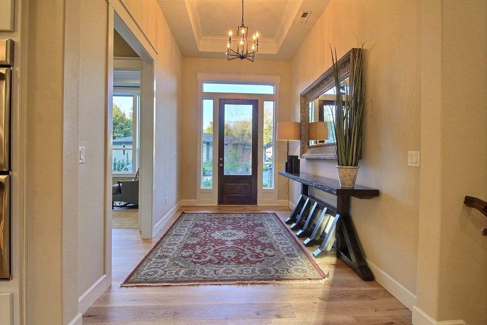 Großes Klassisches Foyer mit beiger Wandfarbe, hellem Holzboden, Einzeltür, hellbrauner Holzhaustür und braunem Boden in Portland