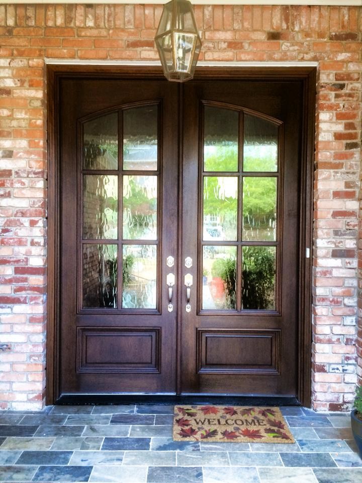 На фото: большая входная дверь в классическом стиле с двустворчатой входной дверью и входной дверью из темного дерева с