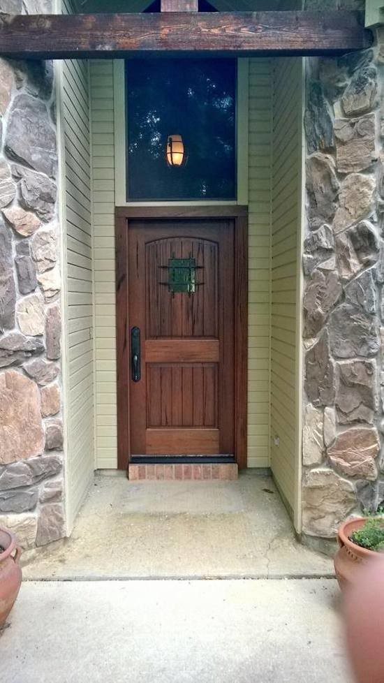 Idée de décoration pour une porte d'entrée chalet de taille moyenne avec une porte simple et une porte en bois brun.