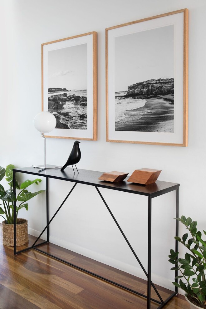 Example of a large 1960s medium tone wood floor and brown floor entryway design in Brisbane with white walls