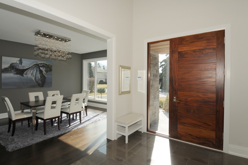 Свежая идея для дизайна: большое фойе в стиле модернизм с одностворчатой входной дверью, входной дверью из дерева среднего тона, серыми стенами и полом из известняка - отличное фото интерьера