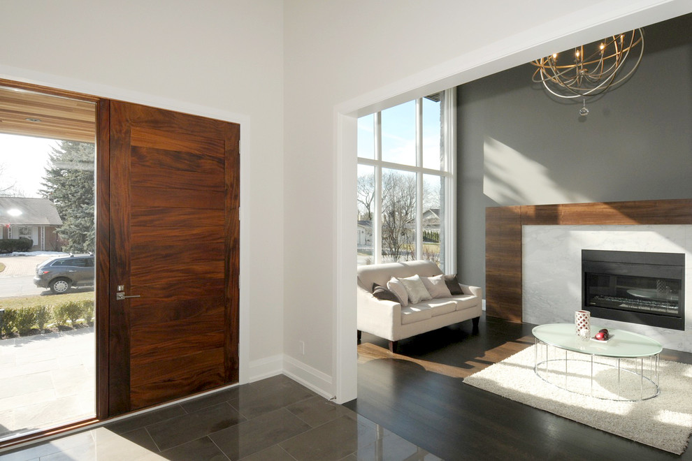 Inspiration pour une grande porte d'entrée minimaliste avec une porte simple, une porte en bois brun, un mur gris et un sol en calcaire.