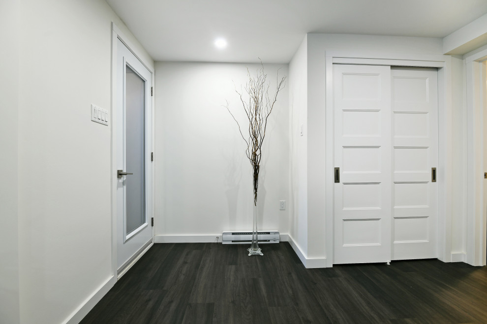 Modelo de entrada actual con paredes grises, suelo vinílico, puerta simple, puerta de vidrio y suelo marrón