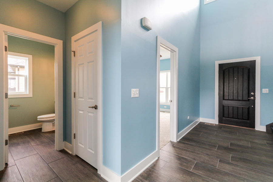 Photo of a medium sized farmhouse foyer in Chicago with blue walls, ceramic flooring, a single front door, a black front door and grey floors.