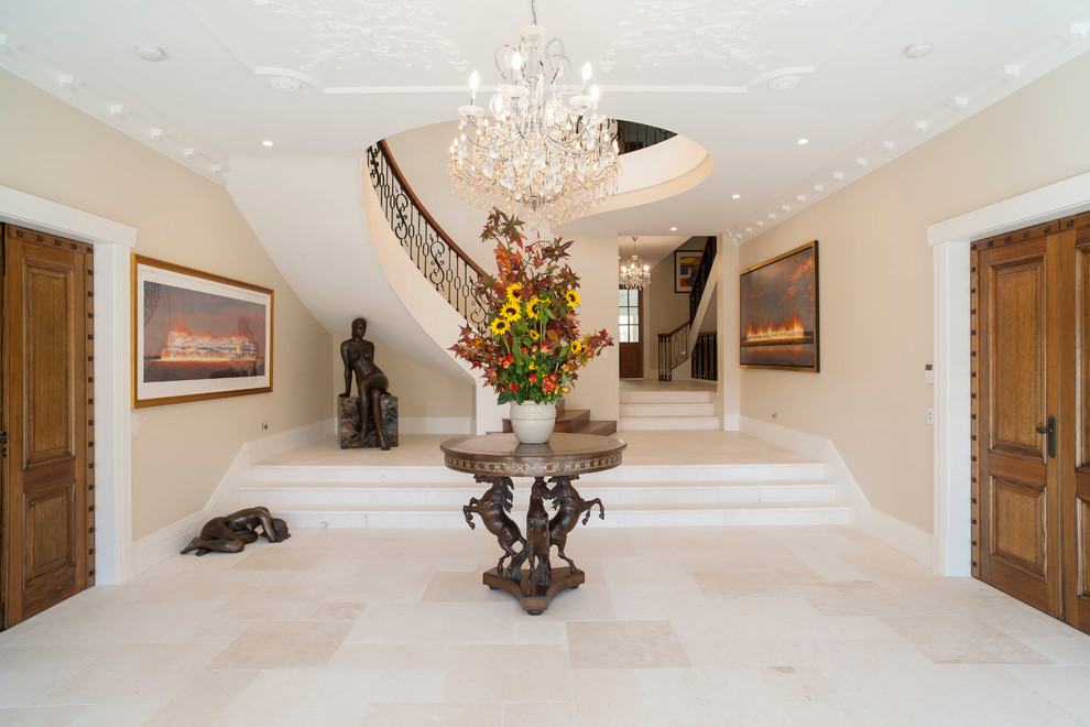 Inspiration for an expansive traditional foyer in Melbourne with limestone flooring, a double front door, a medium wood front door and beige walls.