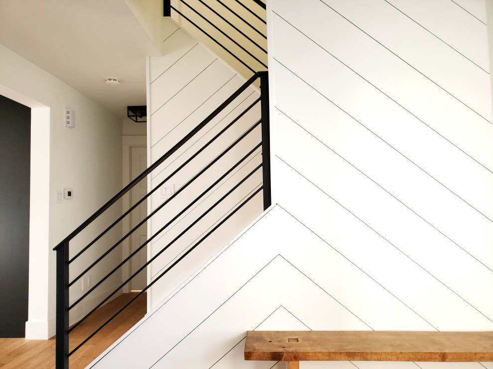 Ispirazione per un piccolo ingresso moderno con pareti bianche, parquet chiaro, una porta singola e pareti in perlinato