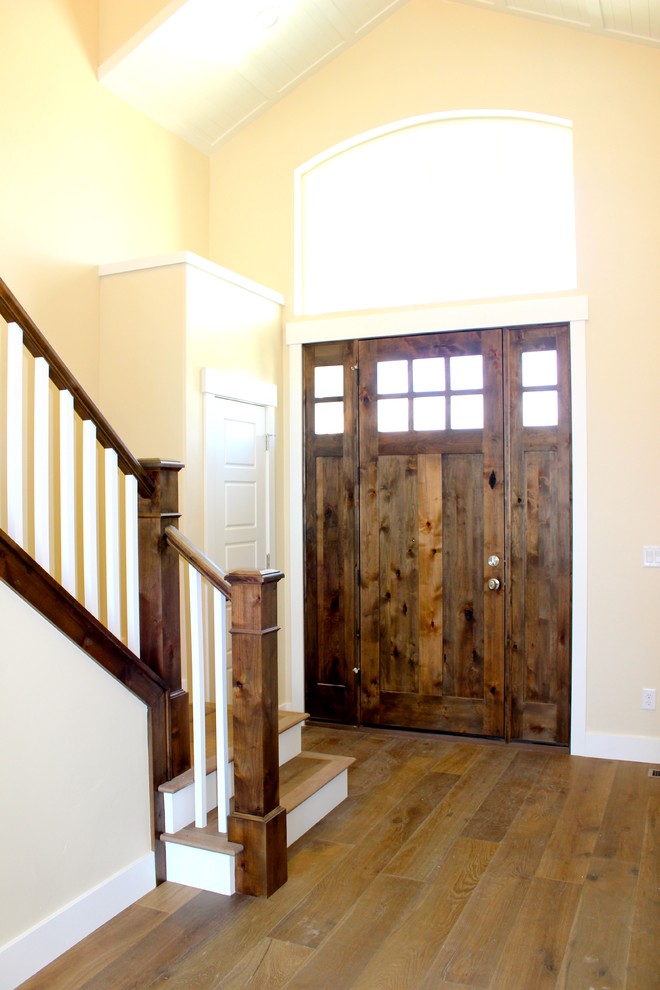 Источник вдохновения для домашнего уюта: большая входная дверь в стиле рустика с желтыми стенами, паркетным полом среднего тона, одностворчатой входной дверью и входной дверью из дерева среднего тона