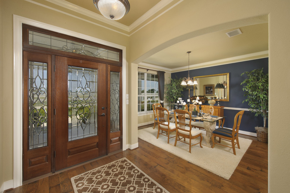 Entryway - mid-sized traditional dark wood floor and brown floor entryway idea in Houston with beige walls and a dark wood front door