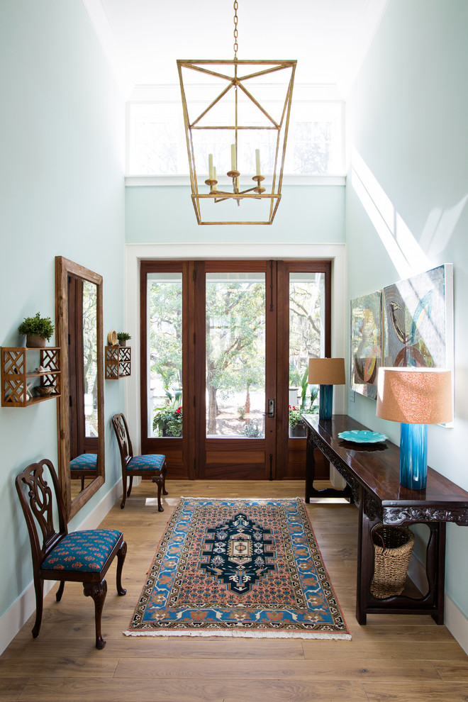 Стильный дизайн: фойе среднего размера: освещение в классическом стиле с синими стенами, паркетным полом среднего тона, одностворчатой входной дверью, стеклянной входной дверью и коричневым полом - последний тренд