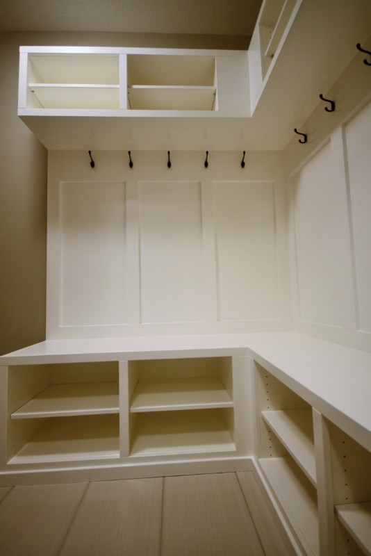 Example of a mid-sized minimalist ceramic tile mudroom design in Calgary with beige walls and a white front door