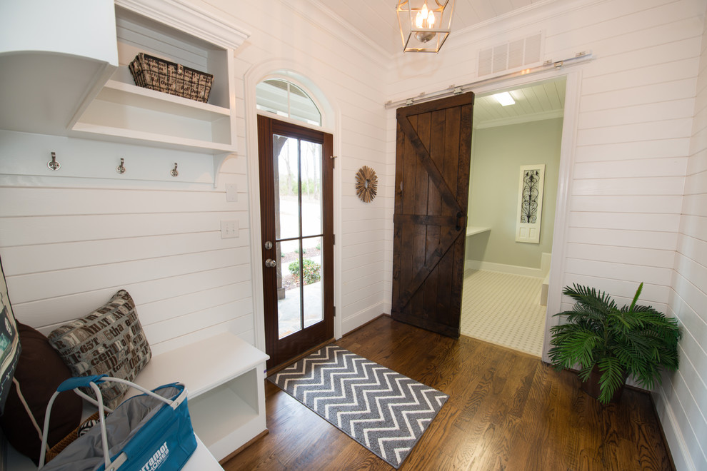 Elegant medium tone wood floor entryway photo in Raleigh with white walls and a medium wood front door