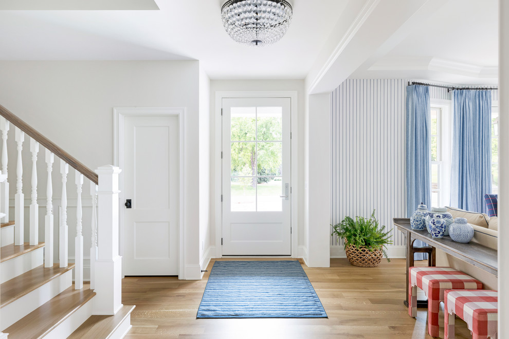 Inspiration for a large coastal light wood floor and brown floor entryway remodel in Minneapolis with white walls and a white front door