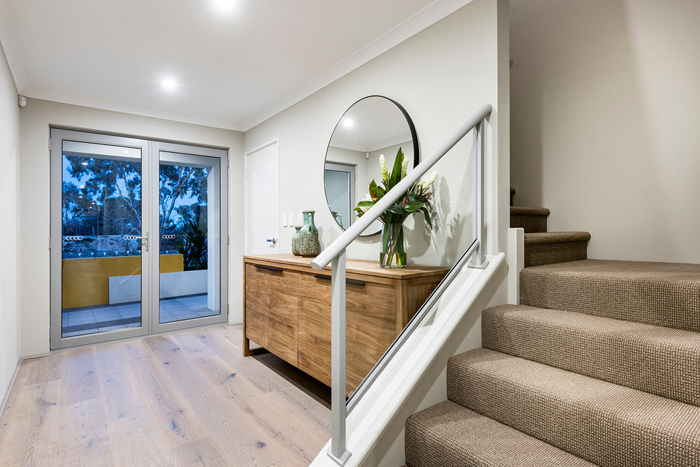 Kleines Modernes Foyer mit weißer Wandfarbe, hellem Holzboden und Haustür aus Glas in Perth