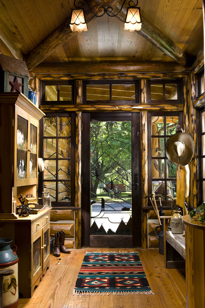 Ejemplo de distribuidor rural con suelo de madera en tonos medios, puerta simple y puerta de vidrio