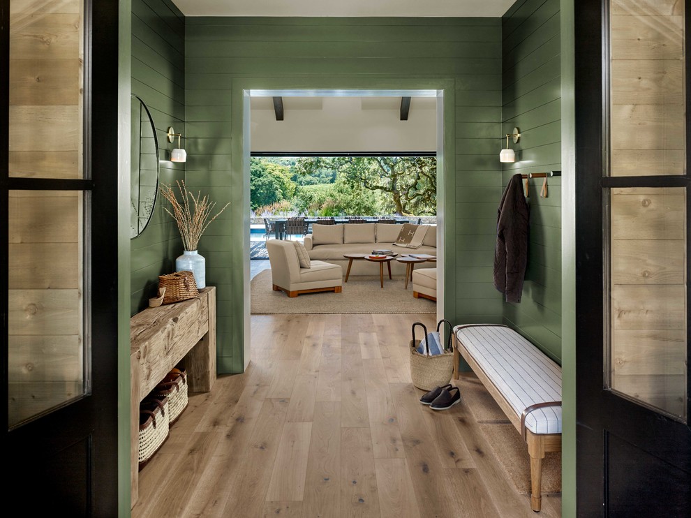 Entryway - cottage light wood floor and beige floor entryway idea in San Francisco with green walls and a black front door