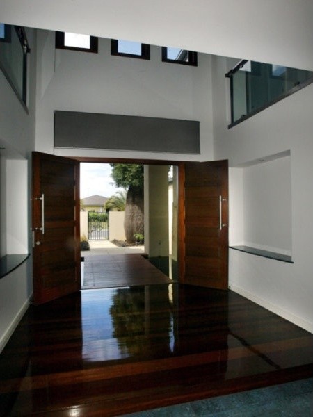 Idee per un grande ingresso minimalista con pareti beige, parquet scuro, una porta a due ante e una porta in legno scuro