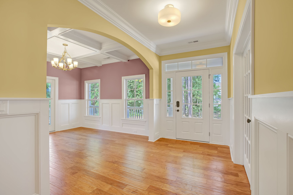 Design ideas for a medium sized traditional foyer in Other with yellow walls, medium hardwood flooring, a single front door and a white front door.