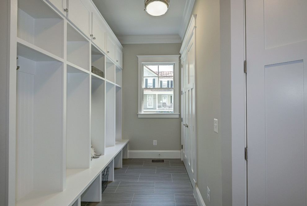 Cette image montre une grande entrée minimaliste avec un vestiaire, un mur gris et un sol en linoléum.