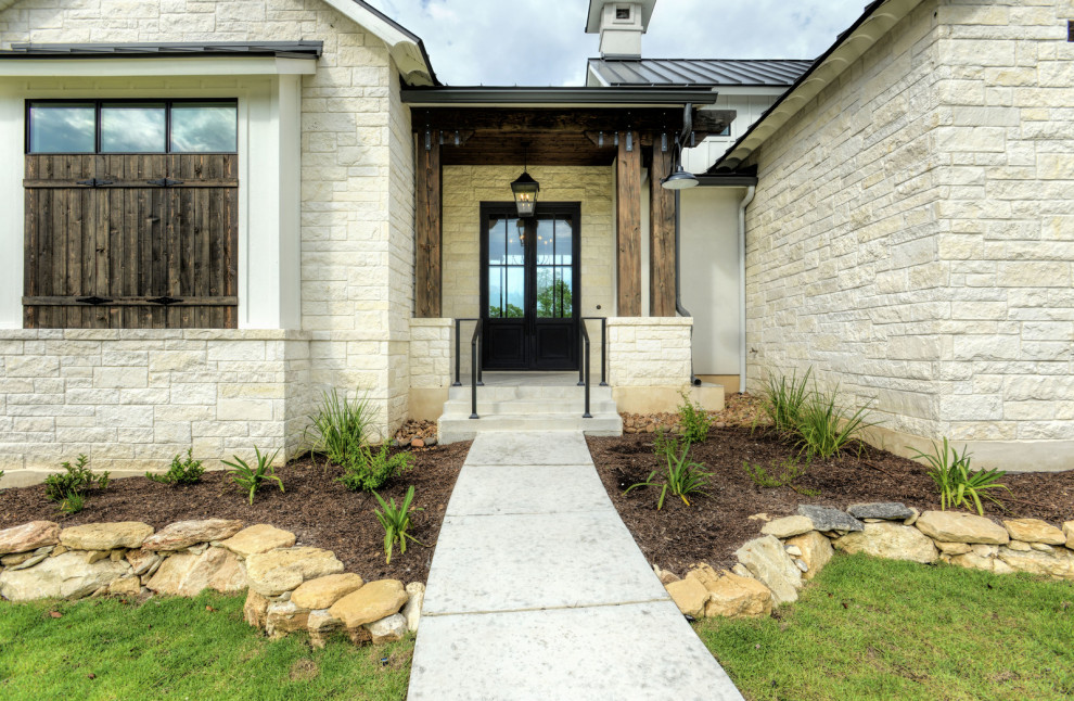 Mittelgroße Landhaus Haustür mit weißer Wandfarbe, gebeiztem Holzboden, Doppeltür, brauner Haustür, braunem Boden, freigelegten Dachbalken und Holzdielenwänden in Austin