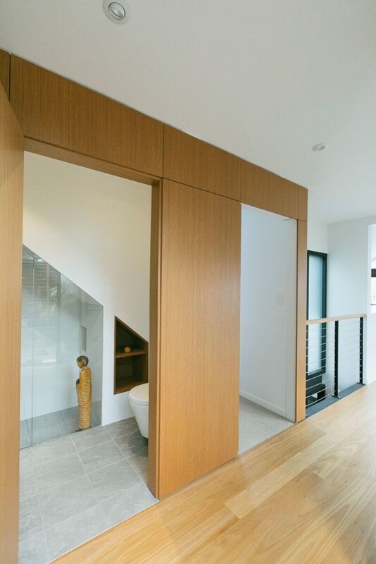 Cette photo montre une petite entrée tendance avec un mur blanc, parquet clair, un sol marron, un couloir, une porte simple et une porte en bois brun.