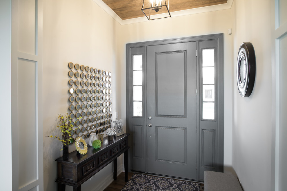 Ispirazione per una porta d'ingresso country di medie dimensioni con pareti beige, parquet scuro, una porta singola e una porta grigia