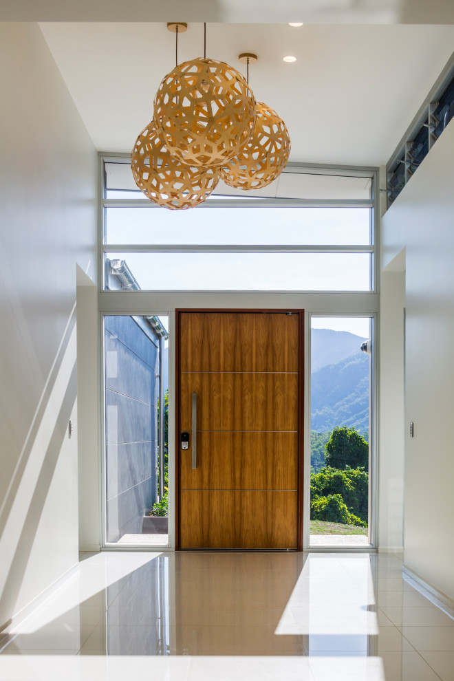 Mittelgroßes Modernes Foyer mit weißer Wandfarbe, Porzellan-Bodenfliesen, Drehtür, hellbrauner Holzhaustür und gelbem Boden in Cairns