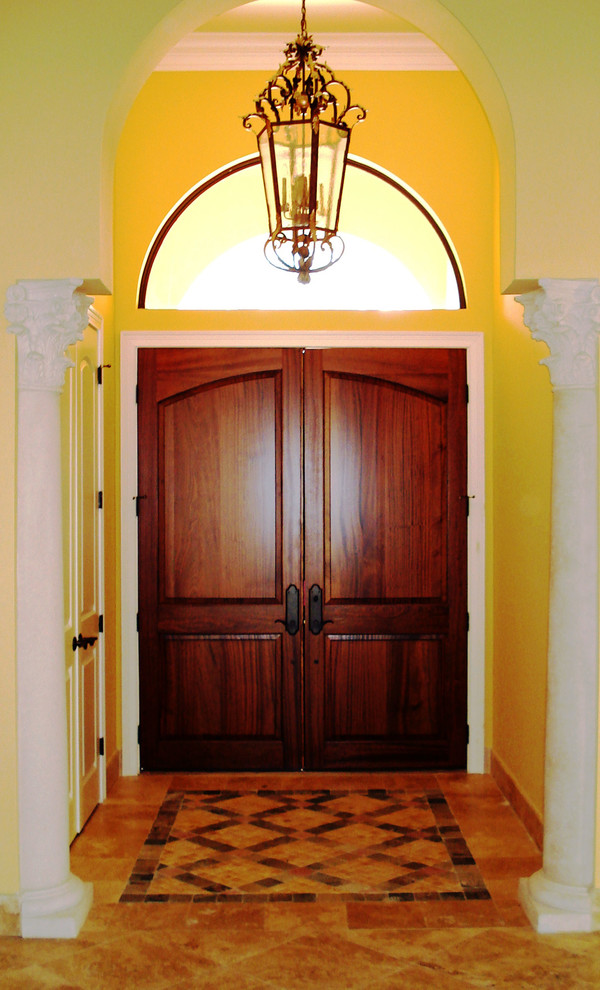 Esempio di un corridoio mediterraneo con pareti gialle, pavimento in marmo, una porta a due ante e una porta in legno scuro