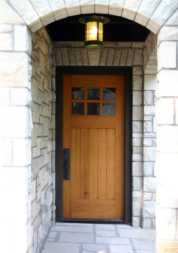 Esempio di un piccolo ingresso con vestibolo chic con una porta singola, pavimento in ardesia e una porta in legno bruno
