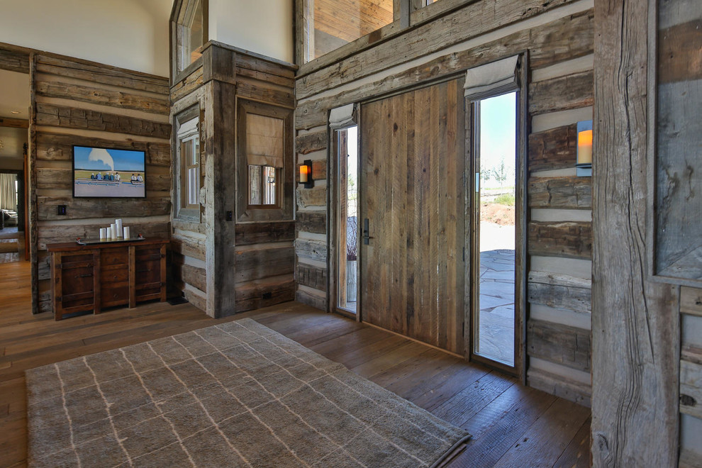 Imagen de distribuidor rural grande con paredes blancas, suelo de madera en tonos medios, puerta simple y puerta de madera en tonos medios