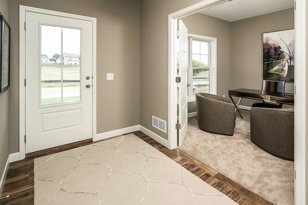 Foto de hall clásico renovado de tamaño medio con paredes beige, suelo de madera oscura, puerta simple y puerta blanca