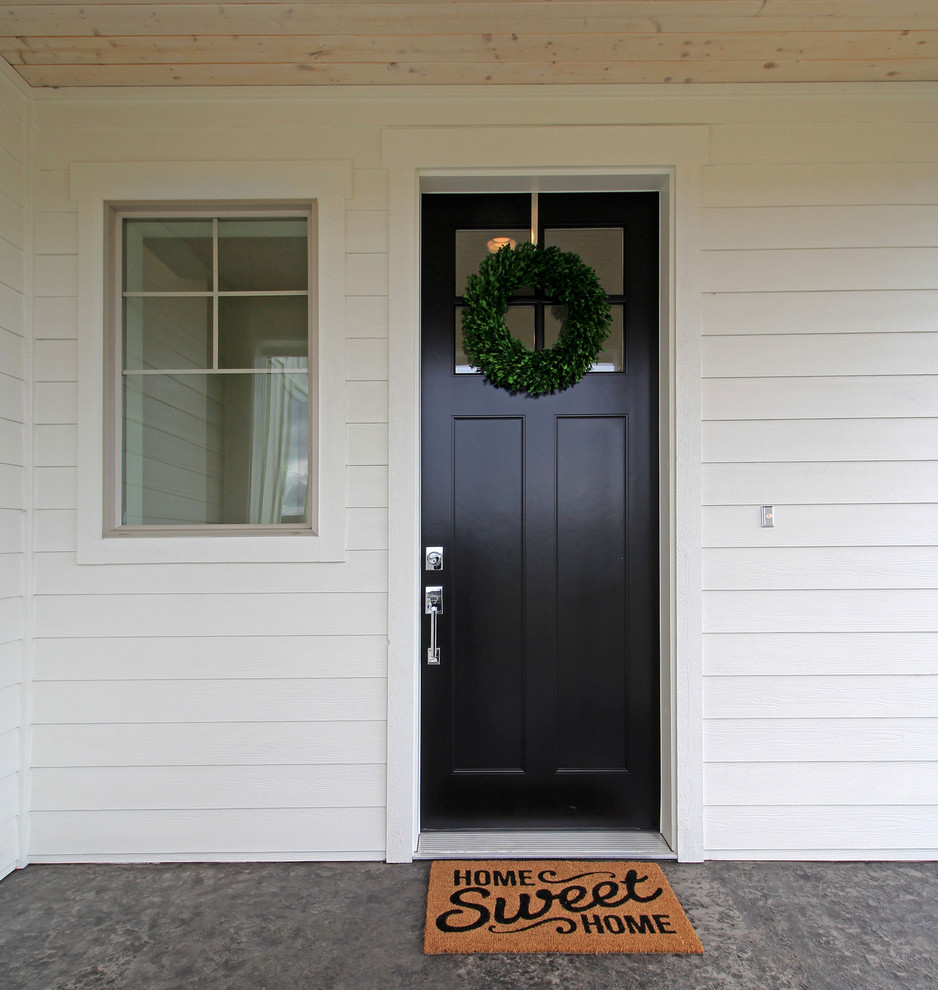 Modelo de puerta principal de estilo de casa de campo de tamaño medio con paredes grises, suelo de madera oscura, puerta simple y puerta blanca