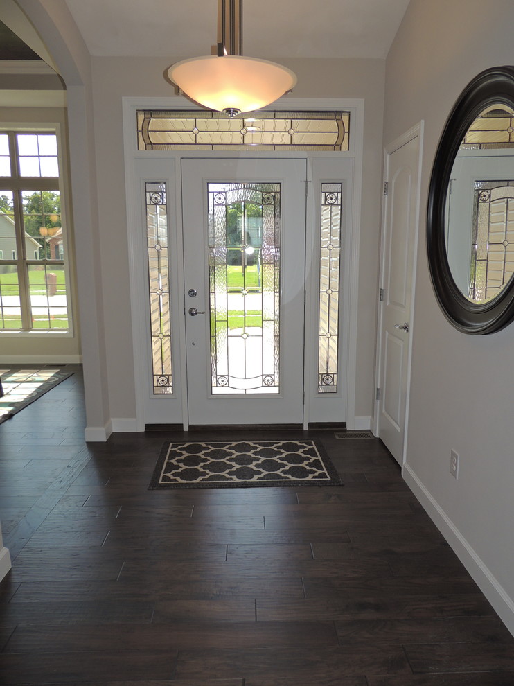 Inspiration for a mid-sized timeless medium tone wood floor entryway remodel in St Louis with white walls and a white front door