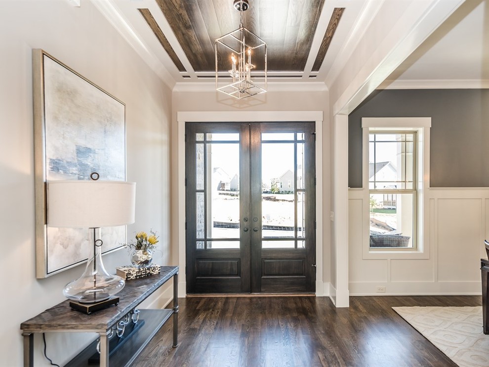 Design ideas for a traditional foyer in Raleigh with beige walls, dark hardwood flooring, a double front door and a dark wood front door.