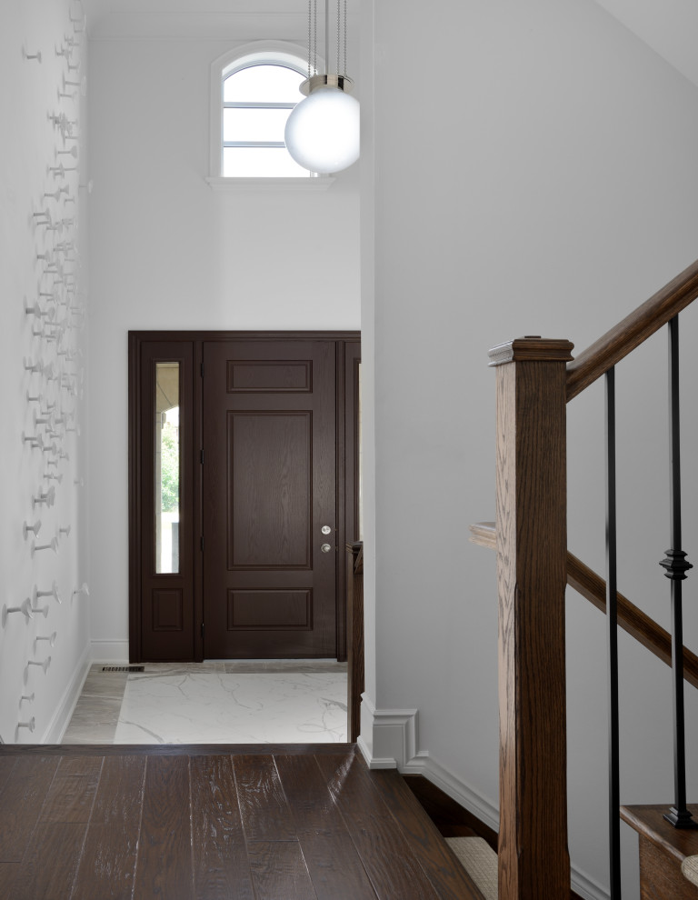 Идея дизайна: фойе среднего размера в стиле неоклассика (современная классика) с белыми стенами, полом из керамогранита, одностворчатой входной дверью, входной дверью из темного дерева, белым полом и кессонным потолком